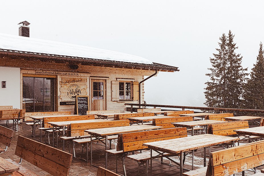 Es schneit auf der Terrasse der Schwendhütte