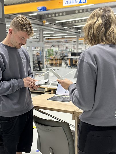 JobQuesterin Pia und ein Mitarbeiter von pester pac arbeiten zusammen in der Werkstatt.