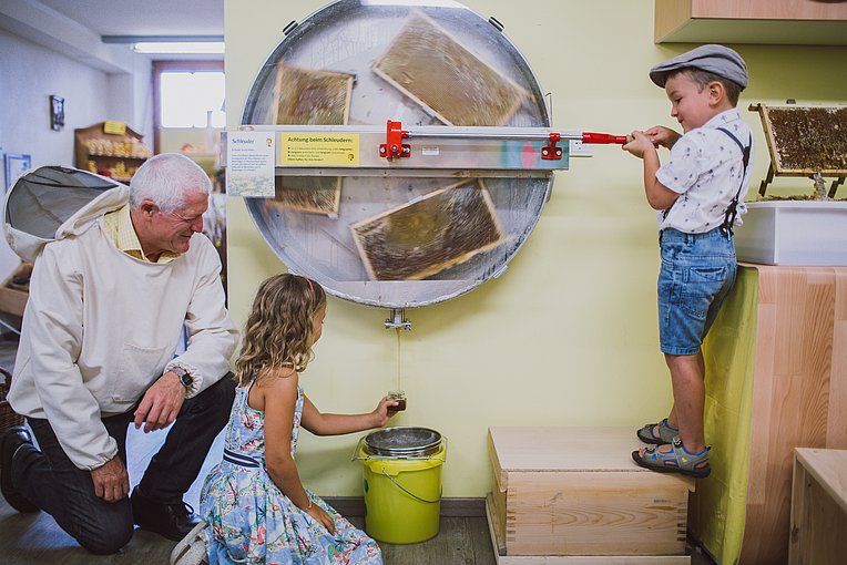 Kinder beim Schleudern von Honigwaben