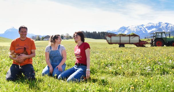 Familie Köpf auf der Weide mit Huhn und Traktor