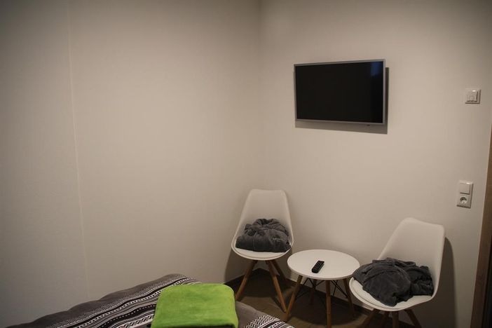 Schlafzimmer mit Flat-TV u. Sitzgelegenheit