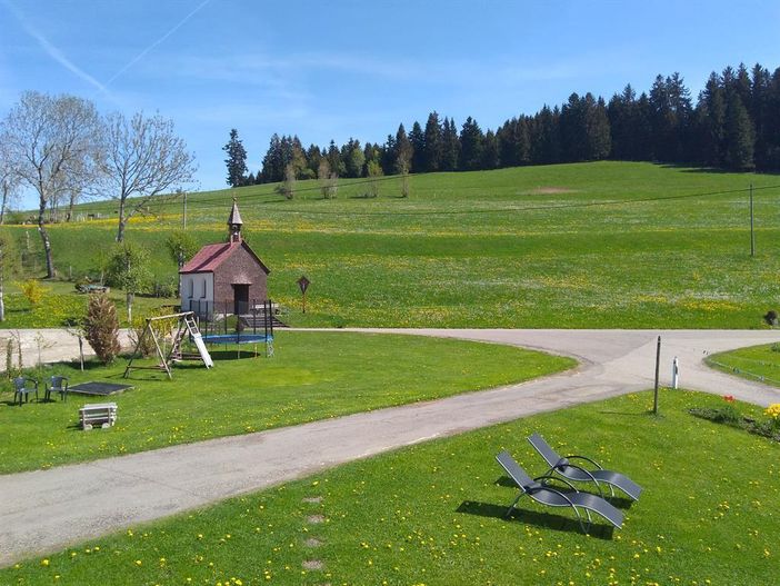 Spielplatz mit Sandkasten, Schaukel und Trampolin