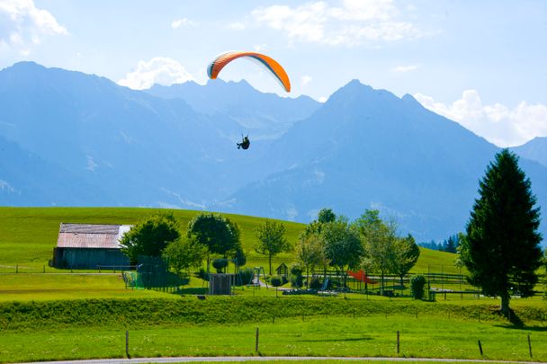 Gleitschirmflieger kurz vor der Landung beim Restaurant Kitzebichl in Bolsterlang