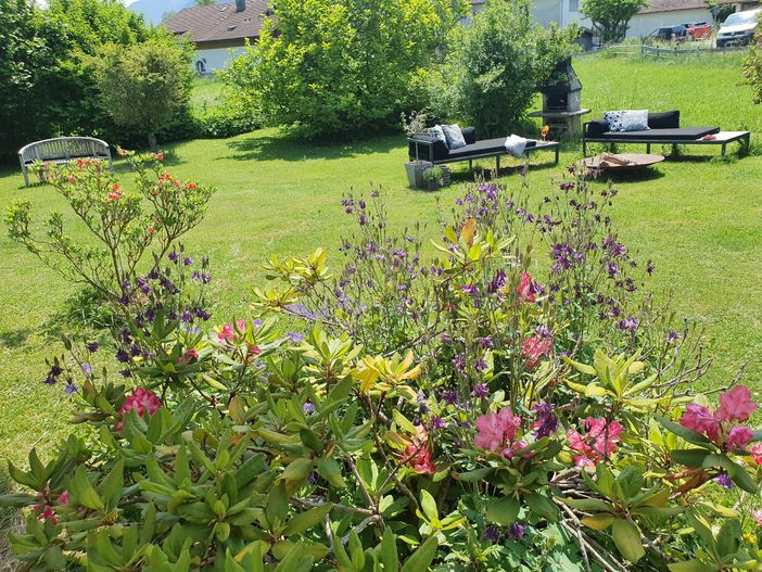 Liegen mit Feuerschale und Blumen im Vordergrund