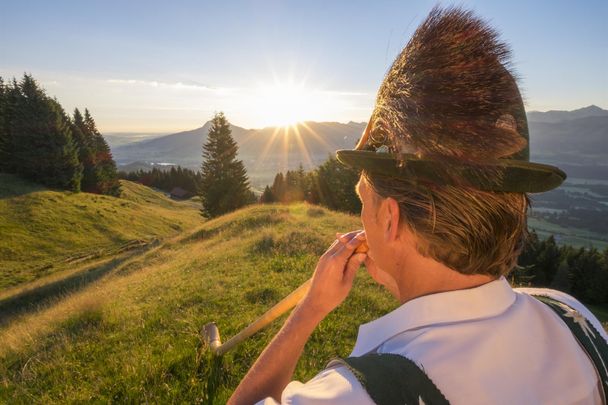 Alphornspieler zum Sonnenaufgang am Ofterschwanger