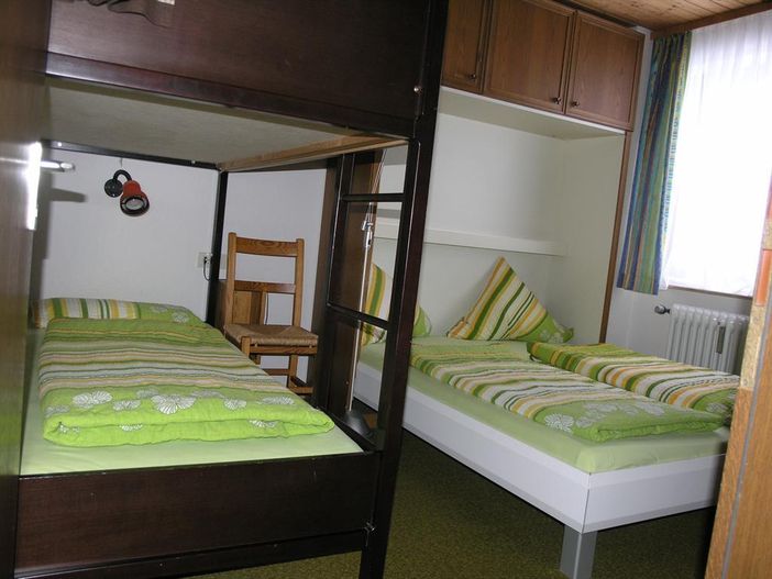 Das Schlafzimmer mit Doppelbett und Etagenbeett