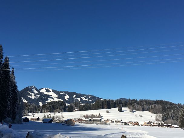 Verschneite Winterlandschaft mit Loipe