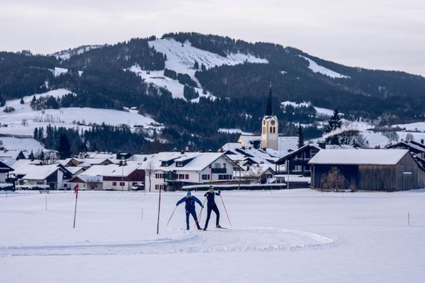 Auf der Kalzhofer Loipe mit der kath. Kirche von Oberstaufen im Hintergrund