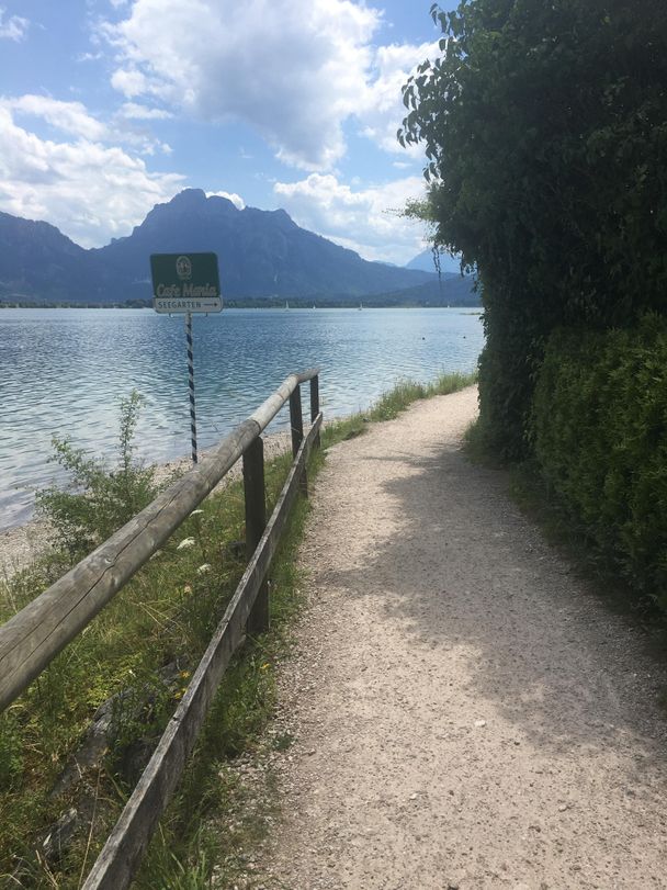 Blick vom Cafe Maria auf den Forggensee und die Bergkette