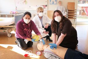 Schulleiterin der Buchloer Krankenpflegehelferschule Cordula Unglert-Heck und Chefärztin der Anästhesiologie Dr. med. Gudrun Nitsche üben mit Schülerin Alisa Lavrenova an einer Reanimationspuppe.